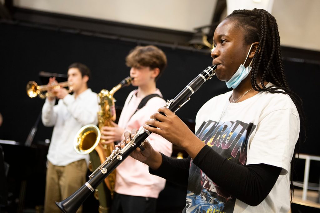 A group of three young musicians play at Academy clubs