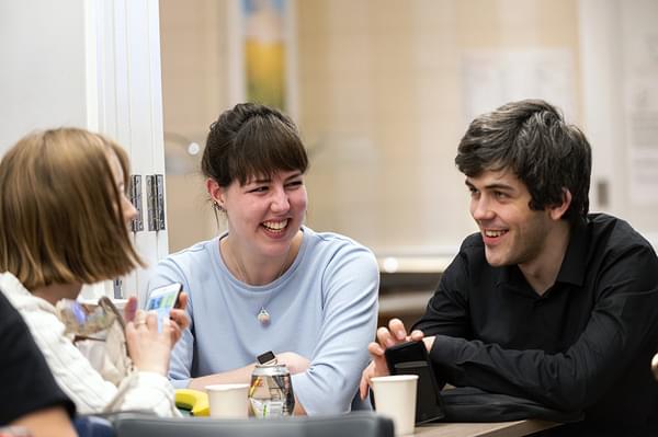 A group of student friends sit together socialising