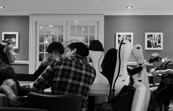 A busy students' union with students sitting amidst instrument cases