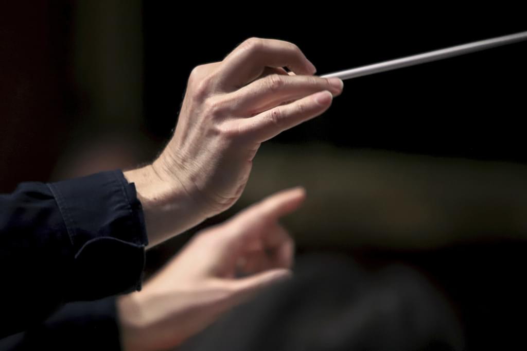 A close up photo of a conductor's hands mid-movement