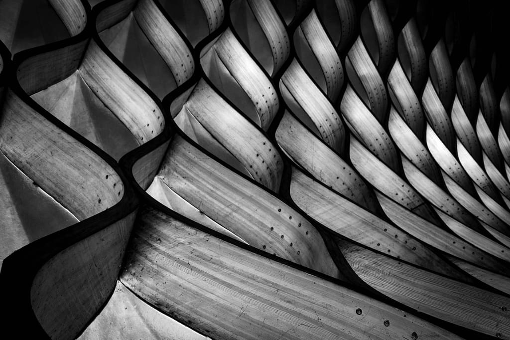 An abstract wooden sculpture with dramatic lighting