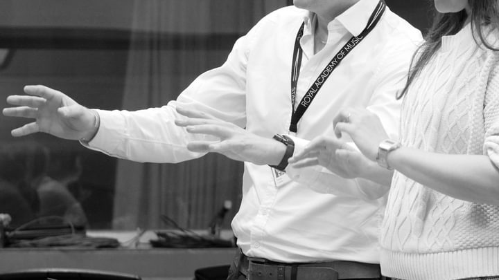 A close-up, black and white image of two conductors' hands in action