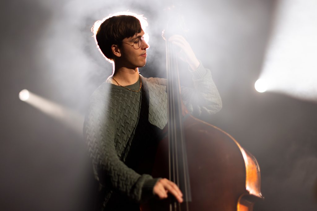 A double bassist bathed in stage lights