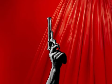 A black and white gun pointing upwards on a red, liquid background
