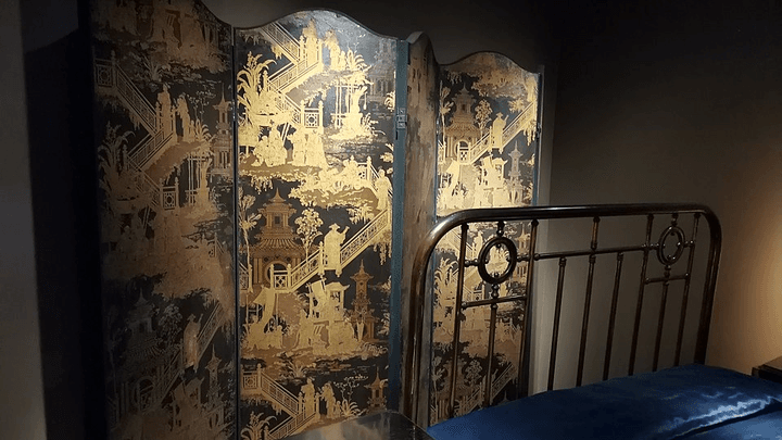 Marcel Proust’s black bed frame with a black and gold screen in the Musée Carnavalet, Paris