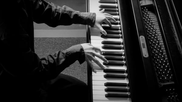 Two hands on a piano keyboard