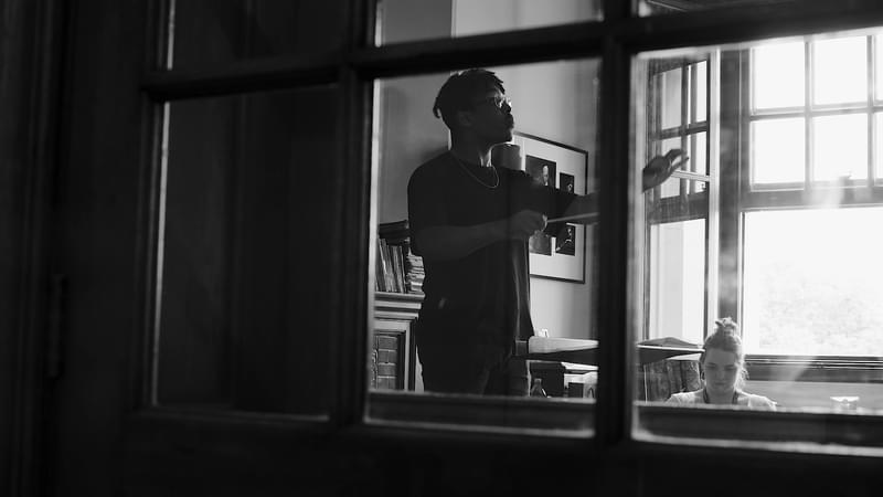 A conducting student practices, viewed through a window