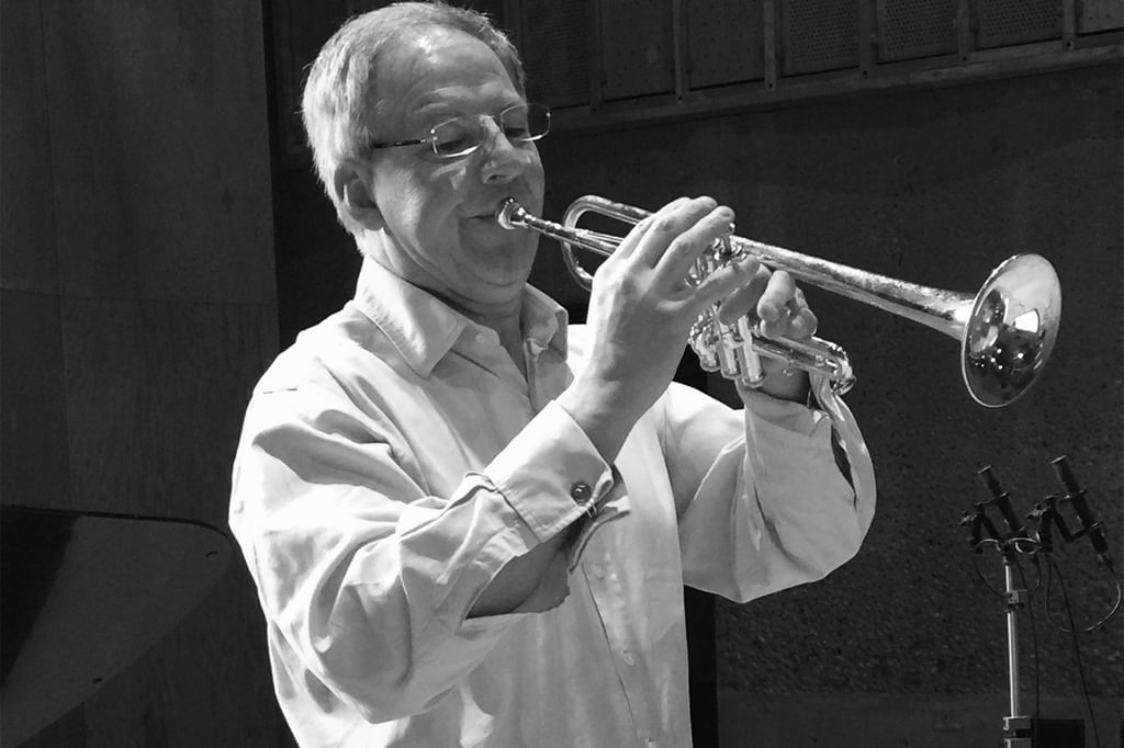 Black and white image of Jonathan Freeman-Attwood playing the trumpet in a recording session