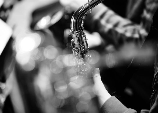 A cose up of a saxophone being played in a brass section