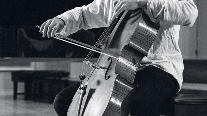 A close up of a cello student's finger movements, mid-performance (black and white)
