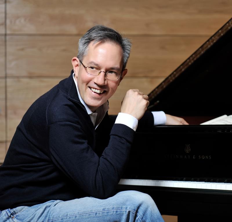 William Fong sits at a piano, looking off camera