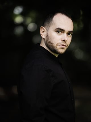 Portrait of conductor Ben Glassberg outside, facing camera