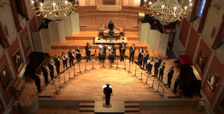 Academy brass performers on the stage of the Duke's Hall, taken from above