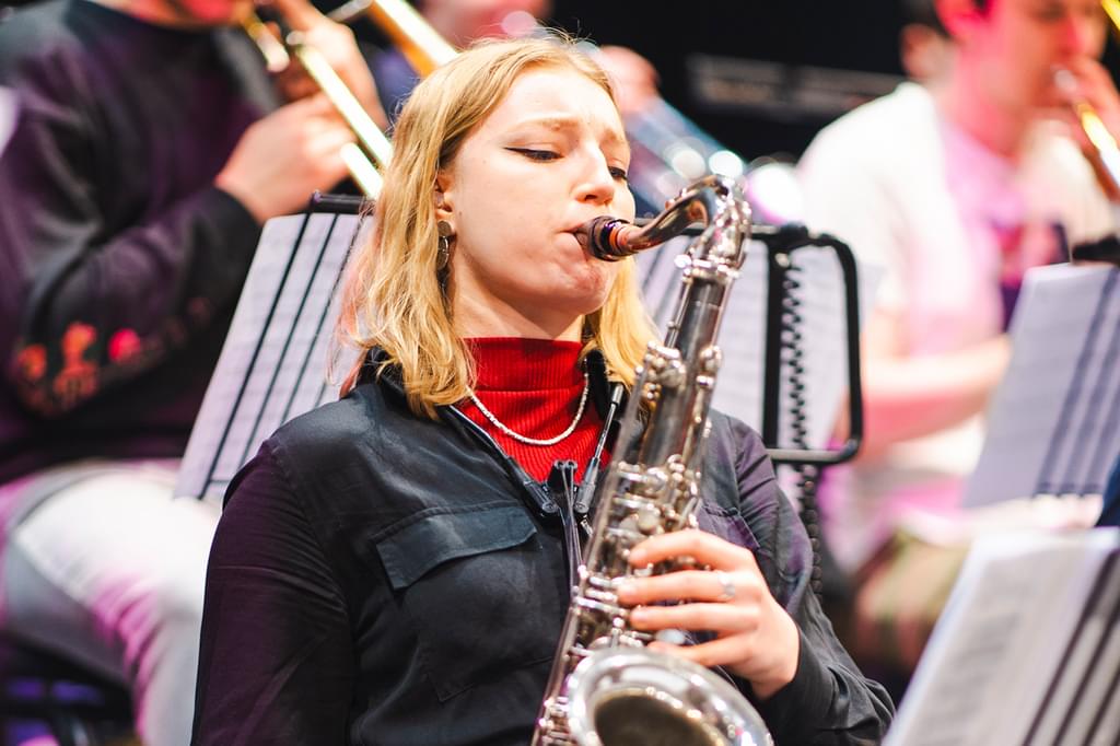 Image of student Emma Rawicz playing the saxophone in rehearsal