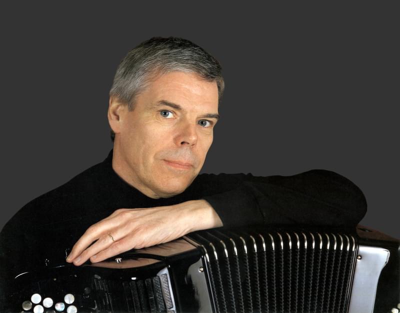 Owen Murray faces camera, with arm resting on top of an accordion