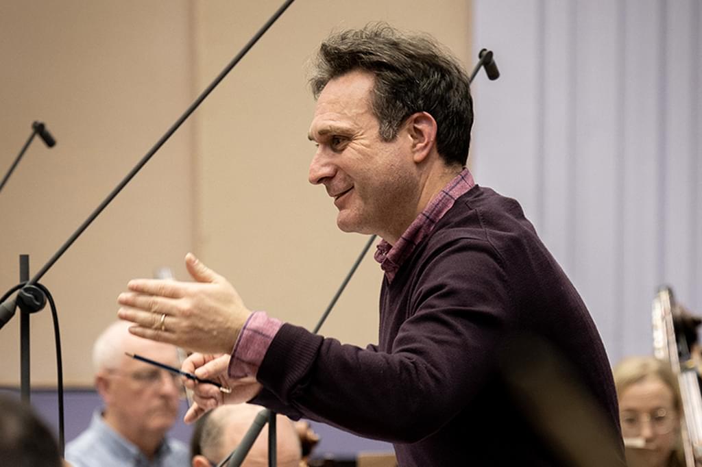A side profile image of Richard Tanner conducting