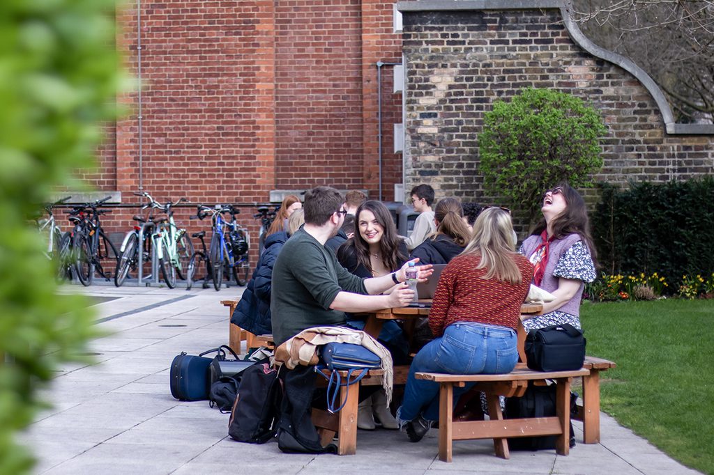 Student sit at a table laughing together