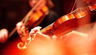 A long shot of two violins with the players' faces absent
