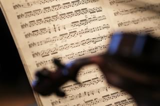 Sheet music viewed from over the shoulder of a violin player