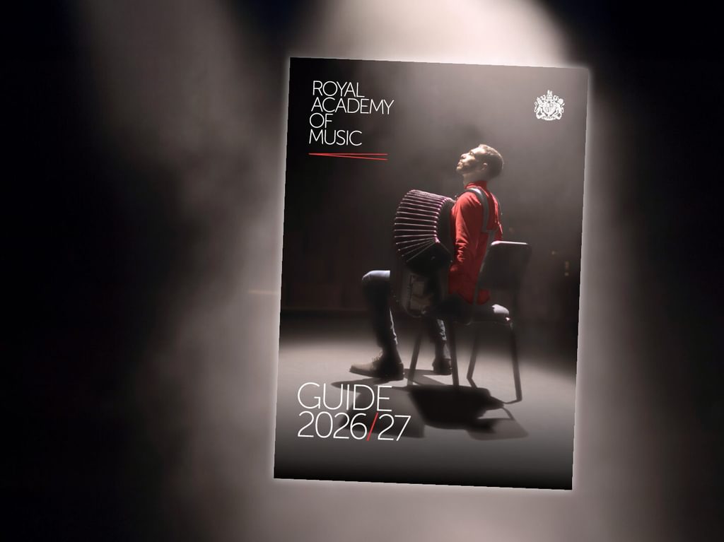 An inset of the front page of a printed guide, with an accordionist draped in a spotlight