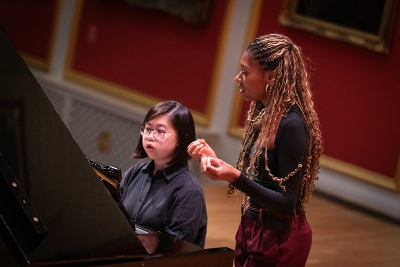 Isata Kanneh-Mason instructing a student at a piano