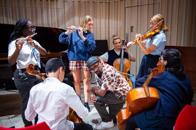 Alexis Ffrench leads an ensemble of young performers in a relaxed setting