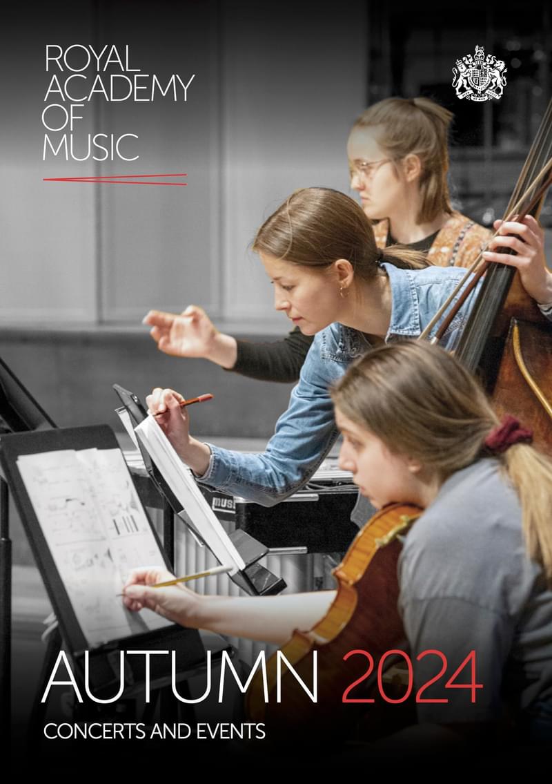 A double bass player annotates sheet music