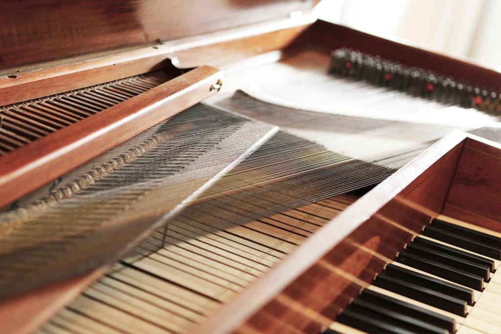 An antique piano with an open lid