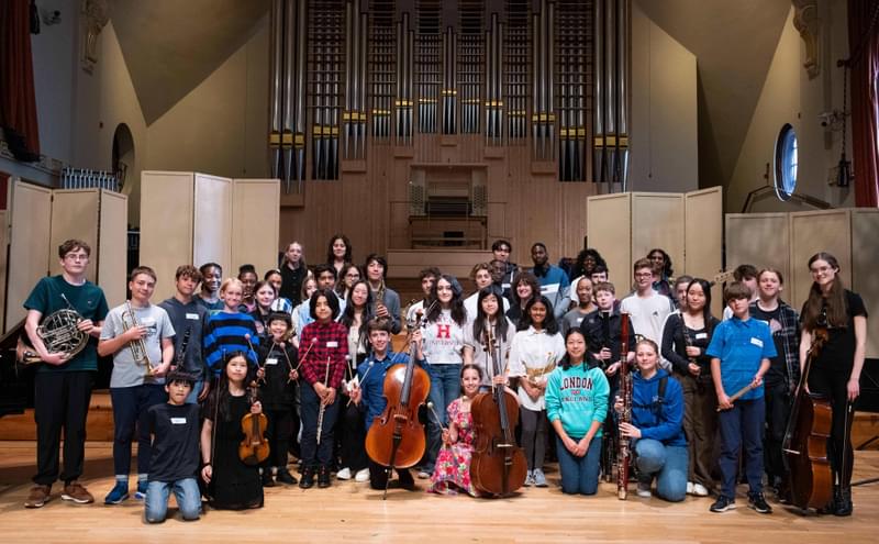 An ensemble of young musicians pose for camera