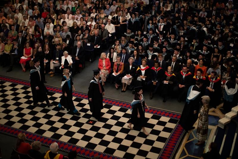 A graduation ceremony procession observed from a balcony