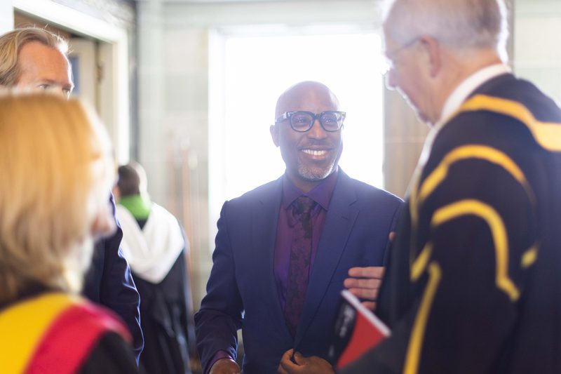 Alexis Ffrench pictured in conversation with a group of people, smiling