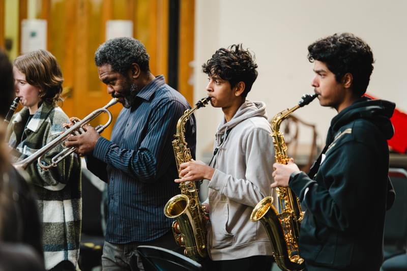 A row of young brass players in rehearsal