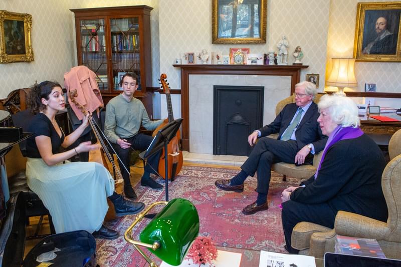 Two string students in discussion with two audience members