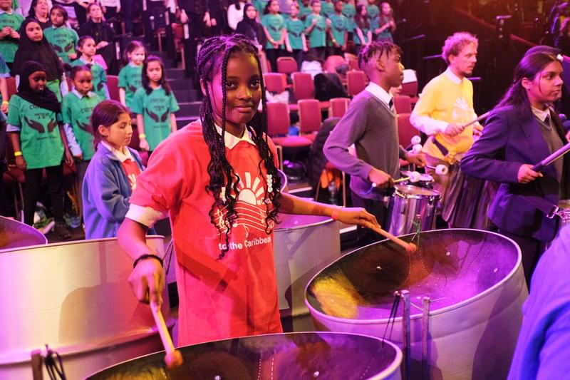 A young drummer smiles to camera