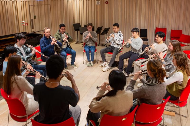 Jonathan Kelly and a group of Academy students sat in a circle, all playing oboes