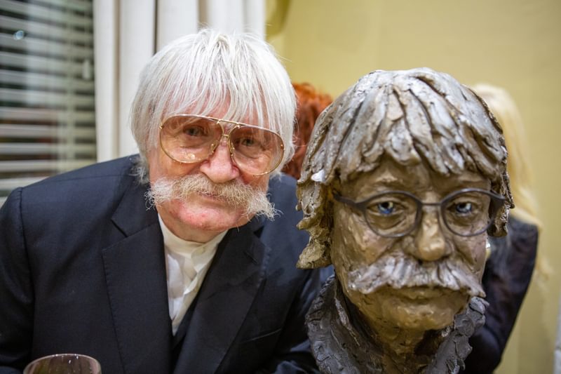 Karl jenkins poses with a bust of himself