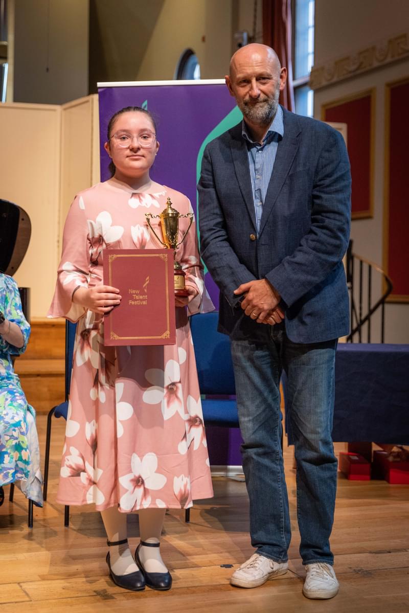 Winner of the new talent festival poses for camera with prize