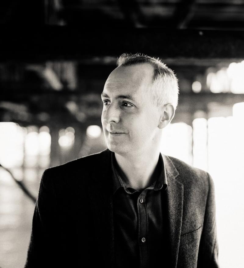Side portrait of David Gorton in a well-lit outdoor space
